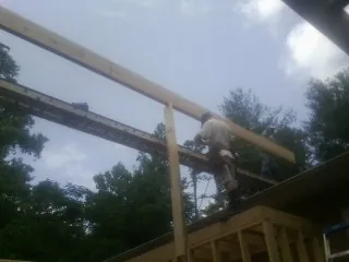 Carpenter setting a ridge beam over a new addition frame — Ice Dam Removal by Roofing Brothers in Wyandotte