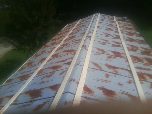 Rusted metal roof panels with new wood purlins before replacement — Storm Damage Roof Repair in Wyandotte by Roofing Brothers