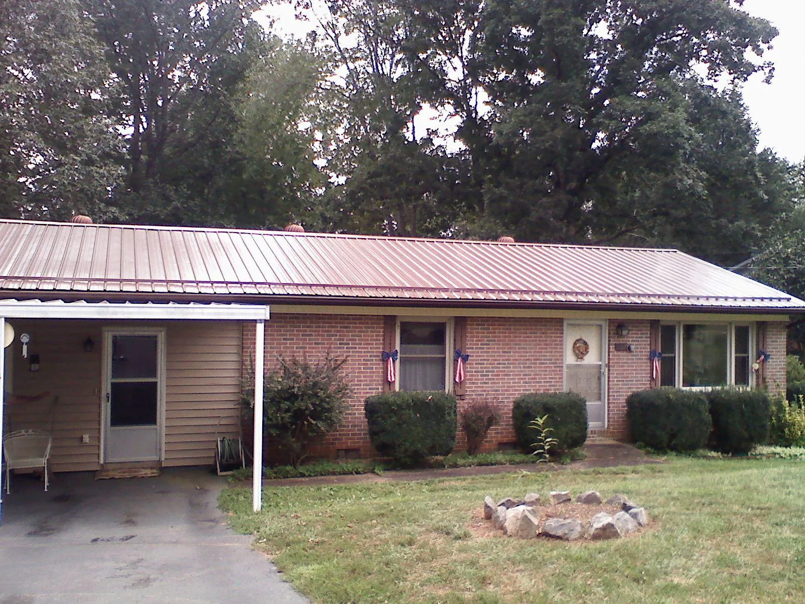 Bronze metal roof and carport on a brick ranch home — Roof Repair work by our crew in Wyandotte